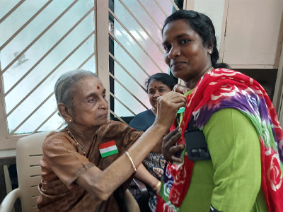 Mrs. Jaya pins a flag on a staff member(Independance Day)